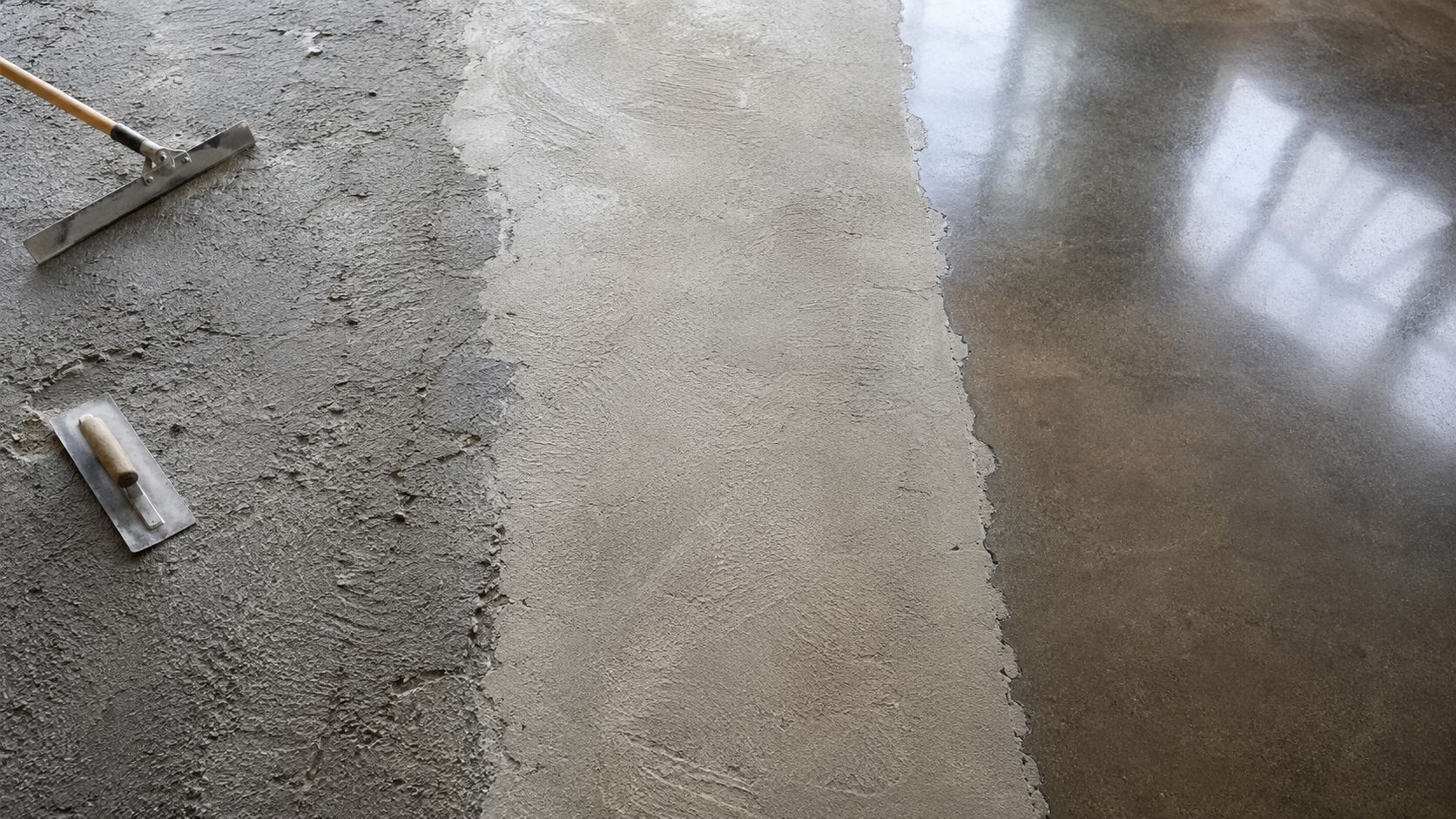 Et betongulv under renovering med værktøj synligt ved siden af både rå og polerede overflader